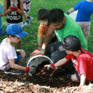 LEAF staff scooping mulch with kids(© 2019 David Shilman / LEAF)