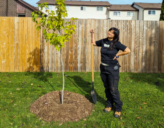 © 2025 LEAF LEAF staff member posing with newly planted tree