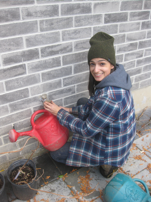 LEAF staff filling a watering jug from outdoor faucet(© 2018 Brenna Anstett / LEAF)