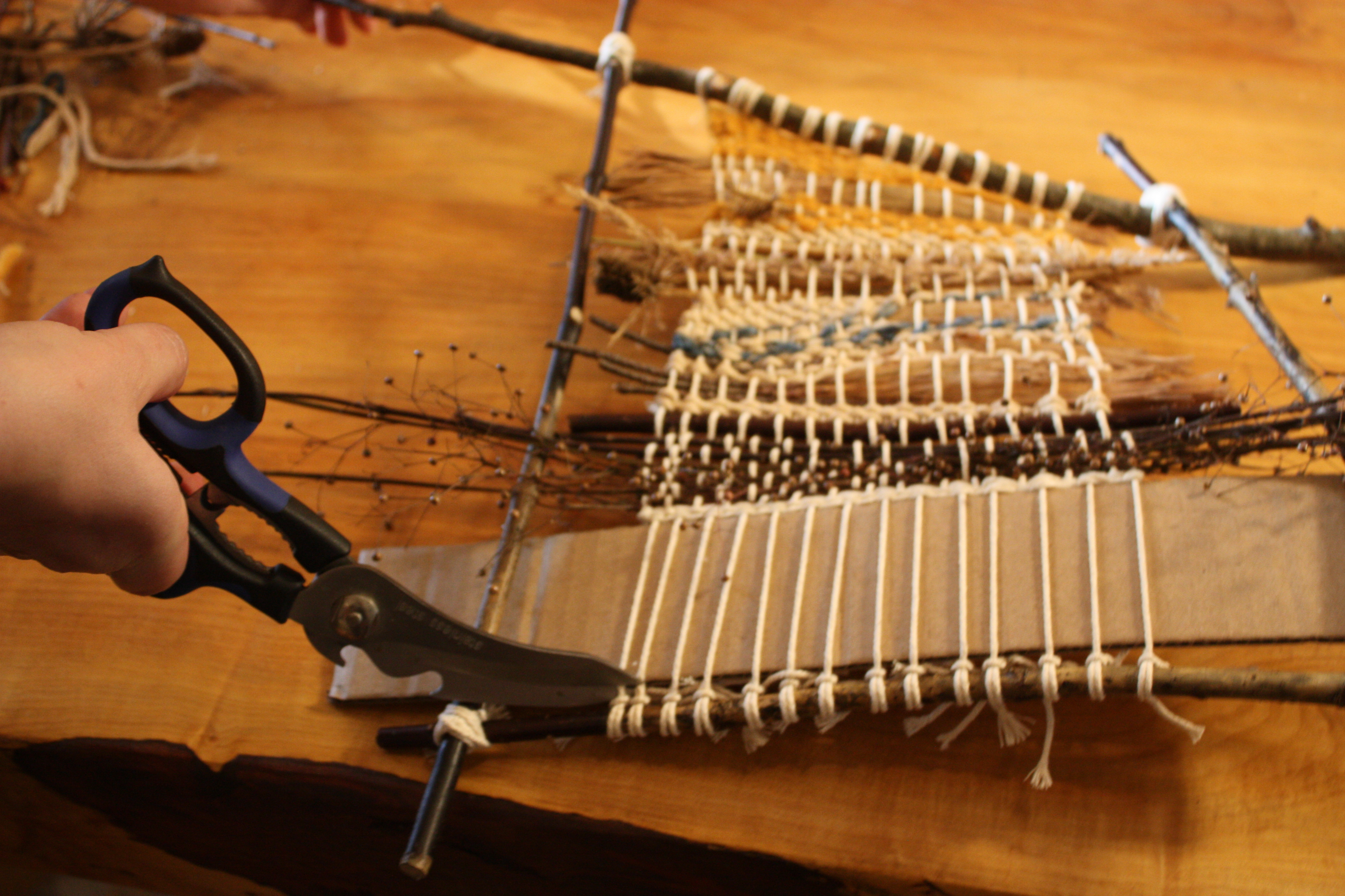 Cutting the bottom warp strings free from the loom