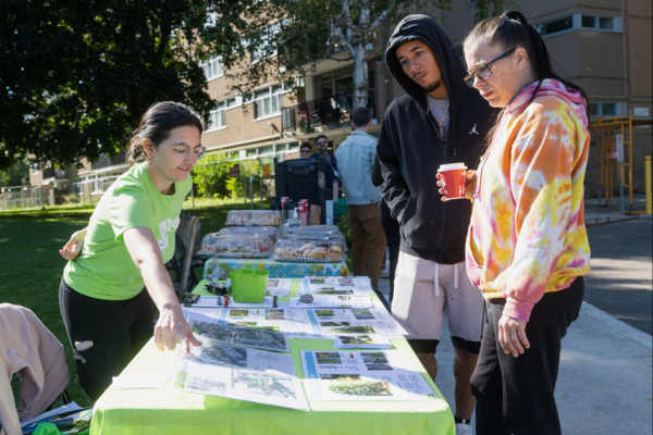 Keyondre visits the LEAF table at the 2024 TCHC Recognition Event, where LEAF staff member Jessie shows various display items