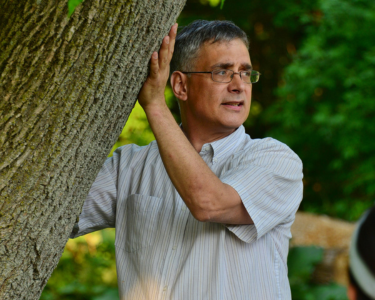 instructor giving lecture next to tree