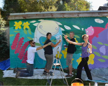 Four people painting a mural at the LEAF Learning Garden