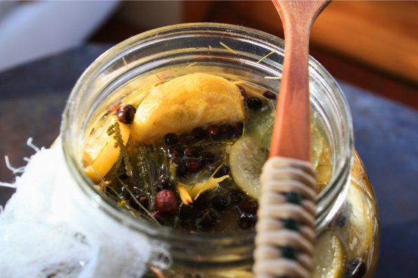 fermented pine soda after several days, with plant material floating and visible carbonation