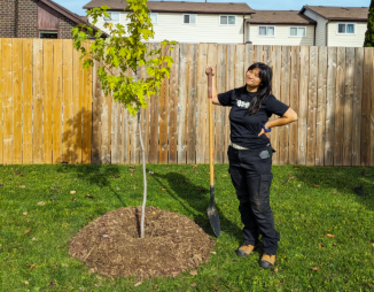 LEAF staff member posing with newly planted tree