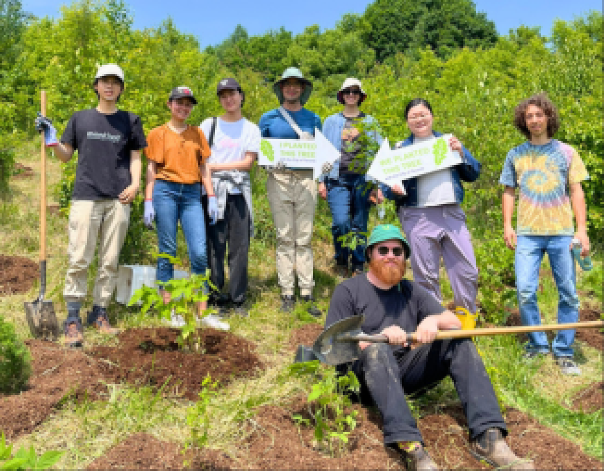 © 2025 Natasha Jovanovic / LEAF A group of YUFL participants pose with shovels and planting signs at a City of Toronto tree planting event on a sunny day.
