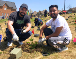 two volunteers posing at a LEAF community planting event