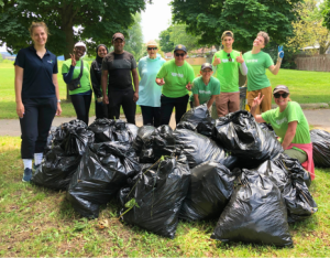 Volunteers and LEAF staff posing with bags filled with invasive plant material