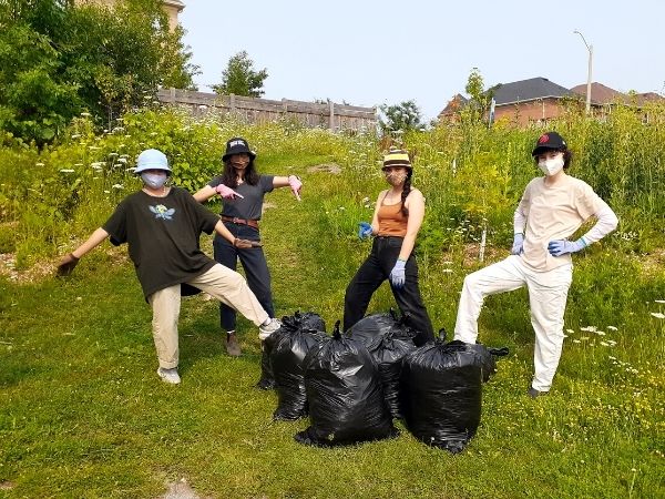Volunteers with bags of invasive plants(©2021 Brian Millward / LEAF)