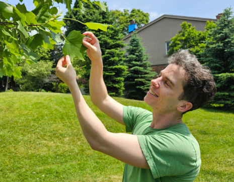 LEAF staff member showing a branch and leaf during a tree tour