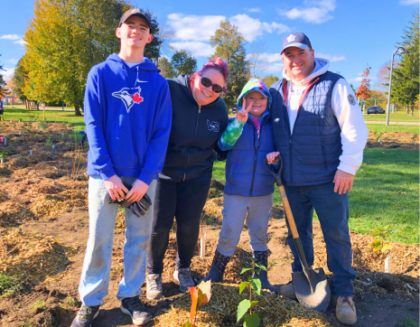 family of four participating at a LEAF community planting event
