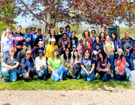 large group of people posing together under a large tree